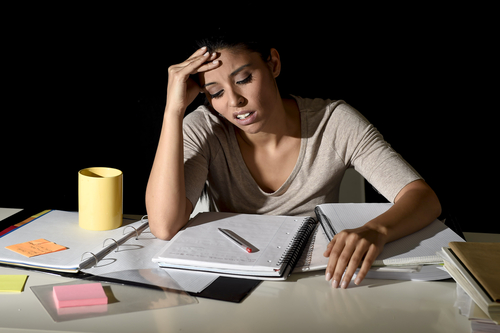 woman sitting at desk, studying at night