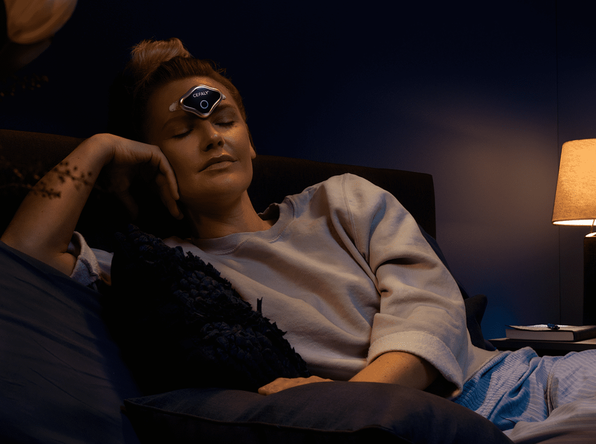 Woman using Cefaly DUAL while relaxing