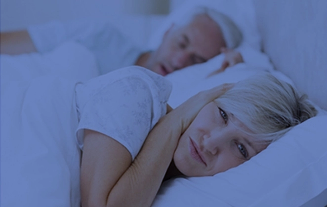 Woman trying to sleep with a snoring partner