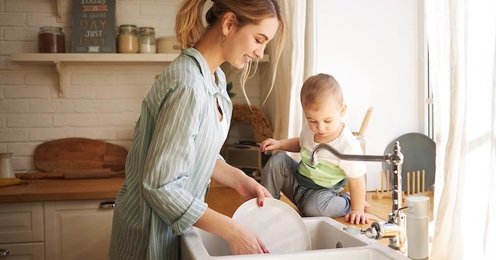 Woman with toddler at the kitchen sink